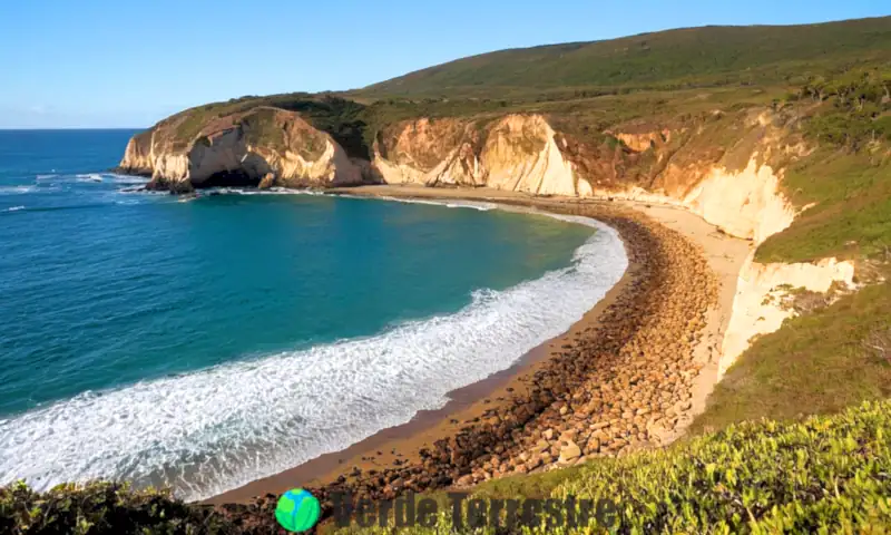 Ilustración realista de erosion marítima, mostrando costas accidentadas, playas de arena y acantilados colapsando bajo un cielo dramático