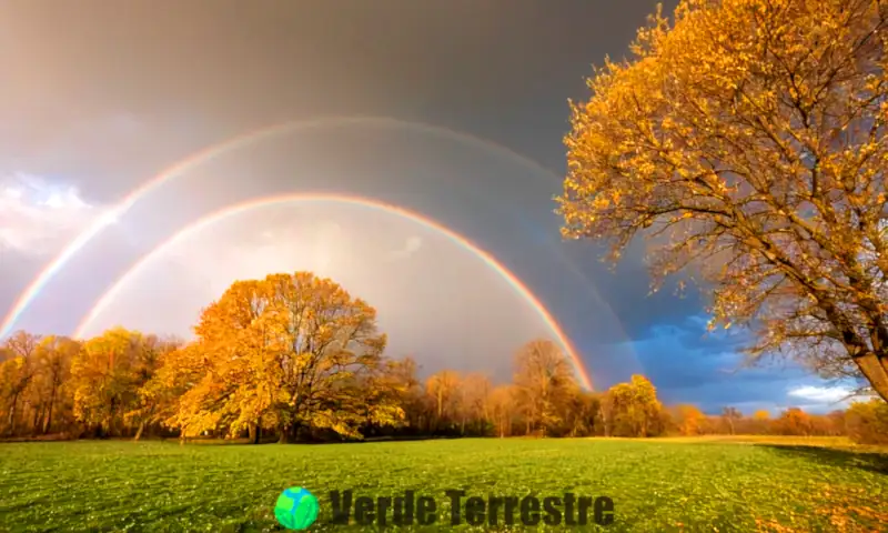 Paisaje sereno con lluvia, nieve, aguanieve y granizo, bajo un cielo brillante con nubes y un sutil arcoíris