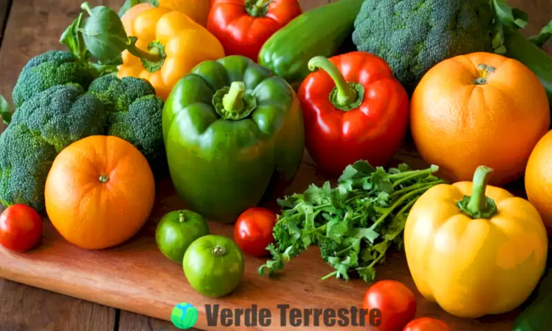 Naturaleza muerta colorida con verduras y frutas frescas sobre una mesa de madera